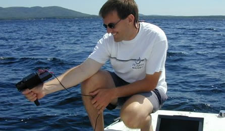 Shane Bradt taking reflectance measurements on a lake
